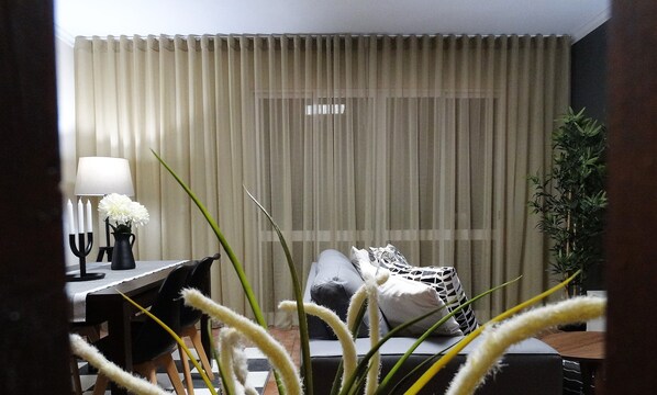Una habitación de hotel con cama, escritorio con lámpara y planta en maceta.