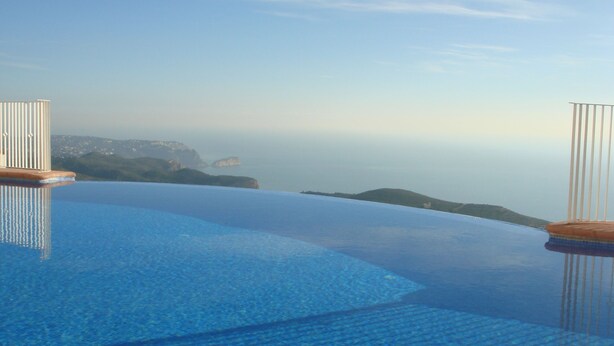Una piscina a sfioro con vista libera sull'oceano e sulla terraferma in lontananza.