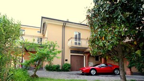 A two-story building with a red sports car parked in front.