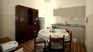 A dining area with a round table, chairs, and a cabinet.