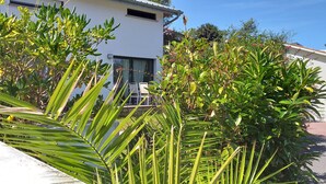 Un bâtiment moderne à l’extérieur blanc, doté de grandes fenêtres et d’un balcon bien visible.