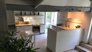 Una cucina moderna con mobili bianchi, un'isola centrale e un forno integrato.