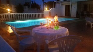 A poolside setting with a table, chairs, and a candle arrangement. - Villa Zsara very near La Fustera In its own grounds with private pool (Calp)