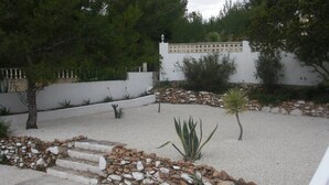 A landscaped garden with a gravel path, stone border, and various plants. - Villa Zsara very near La Fustera In its own grounds with private pool (Calp)