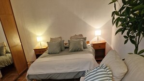A bedroom with a bed, a nightstand, a lamp, and a potted plant. - Villa Zsara very near La Fustera In its own grounds with private pool (Calp)