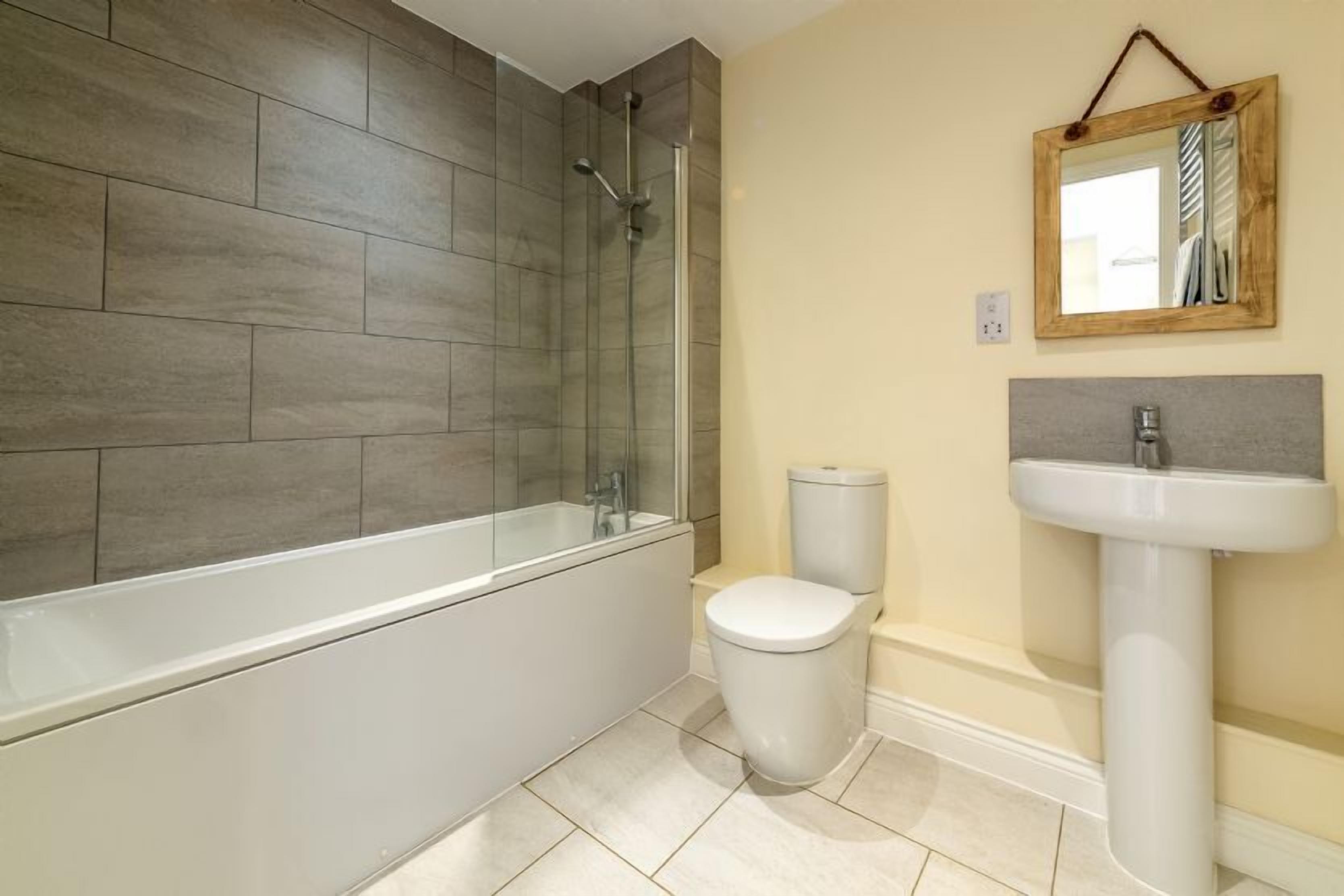 A modern bathroom with a bathtub, toilet, and sink.