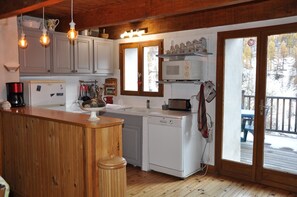 A kitchen with wooden cabinets, a microwave, a coffee maker, and a dishwasher. - apartment/ flat - 6 rooms - 10/14 persons (Crévoux)