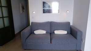 A grey sofa with two white cushions, a framed picture above it, and two wall-mounted lights. - Front line beach penthouse with spectacular views (Gran Tarajal)