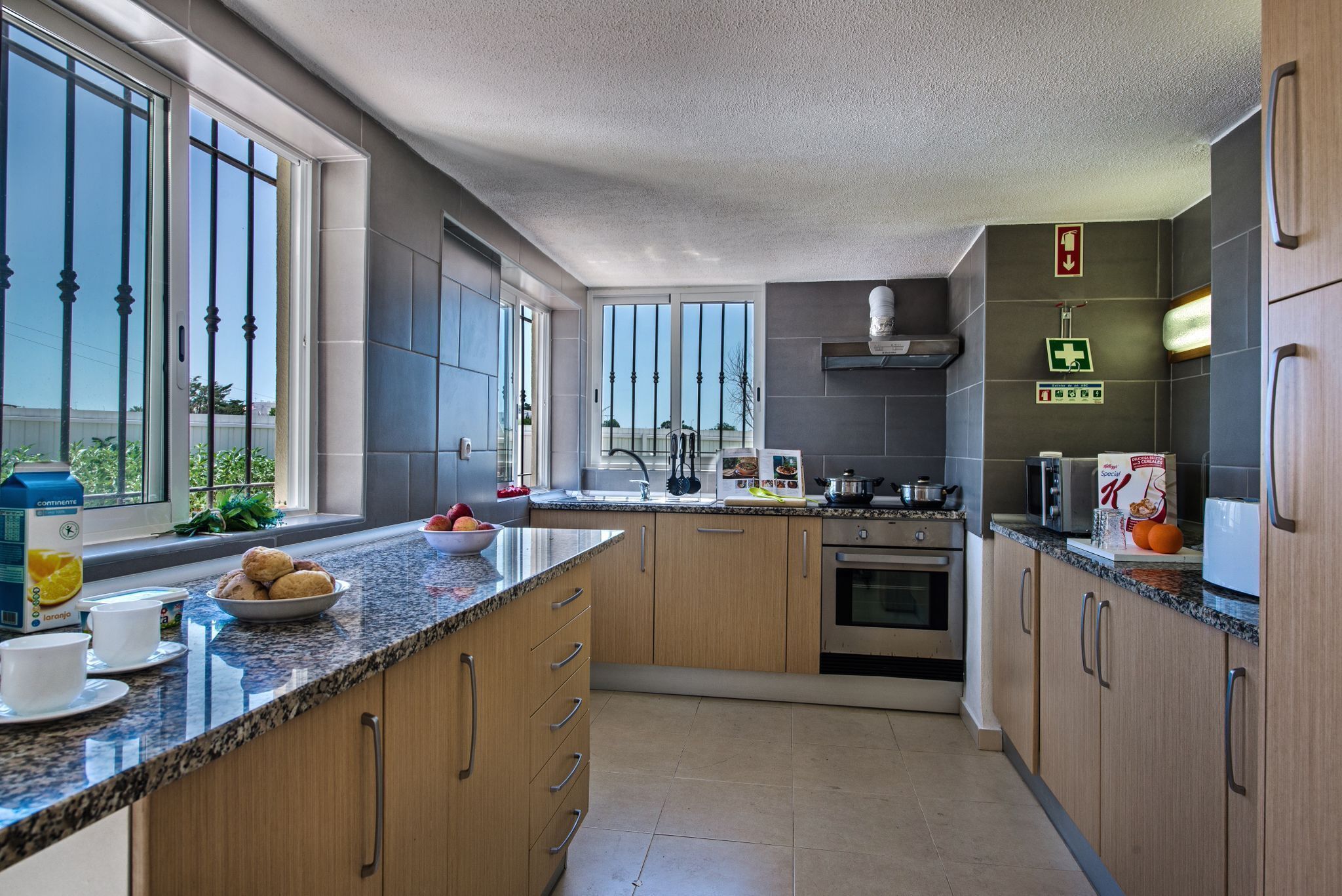 A modern kitchen with granite countertops, wooden cabinets, and a built-in oven.