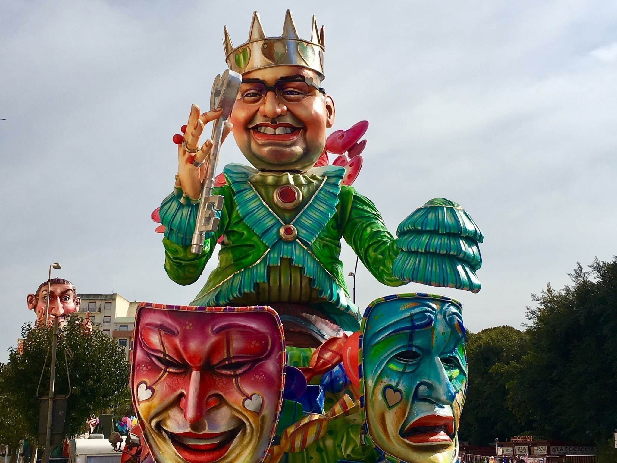 A colorful statue of a figure with a crown, holding a scepter, and wearing a green outfit with red accents.