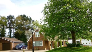 A residential house with a garage, a driveway, and a lawn. - Accessible Holiday Let In Secluded Location (Beacon Hill)
