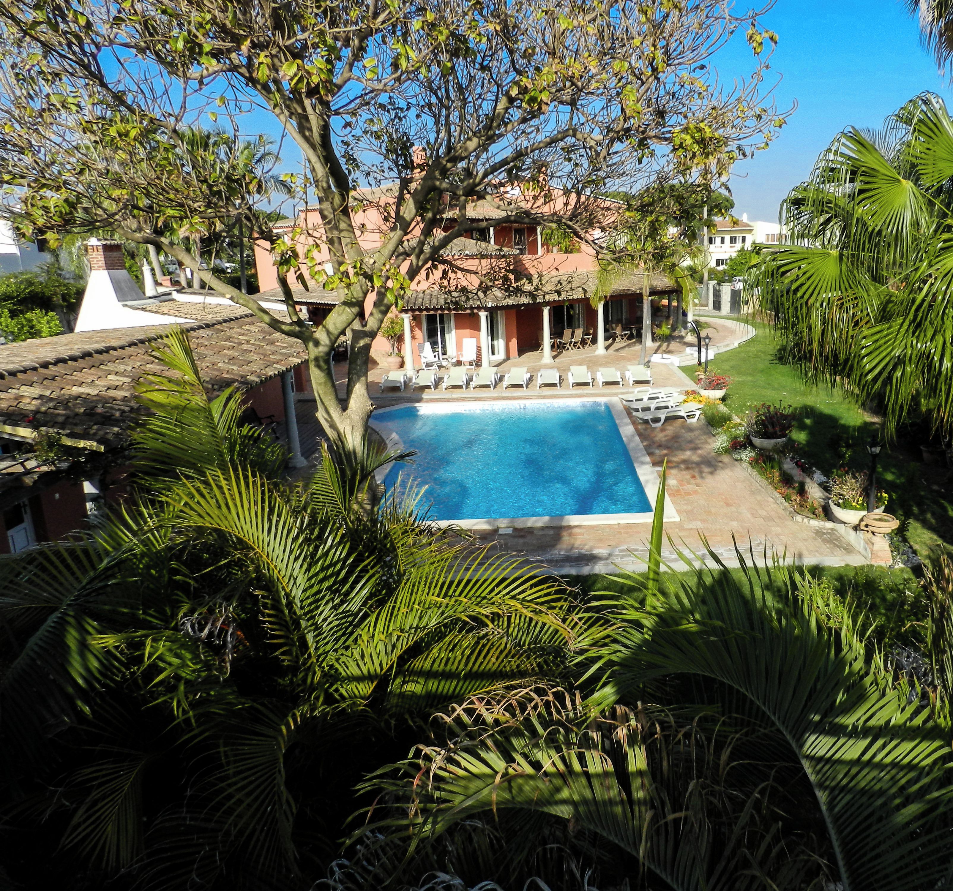 A pool area with lounge chairs and a building in the background.