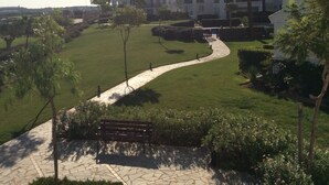 A pathway leading to a building with multiple balconies and a well-maintained lawn. - Hacienda Riquelme Polaris World Golf / Holiday Resort, Sucina, Spain  (Murcia)