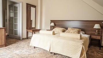 Un dormitorio con una cama grande, dos mesitas de noche, un cabecero de madera y una araña.