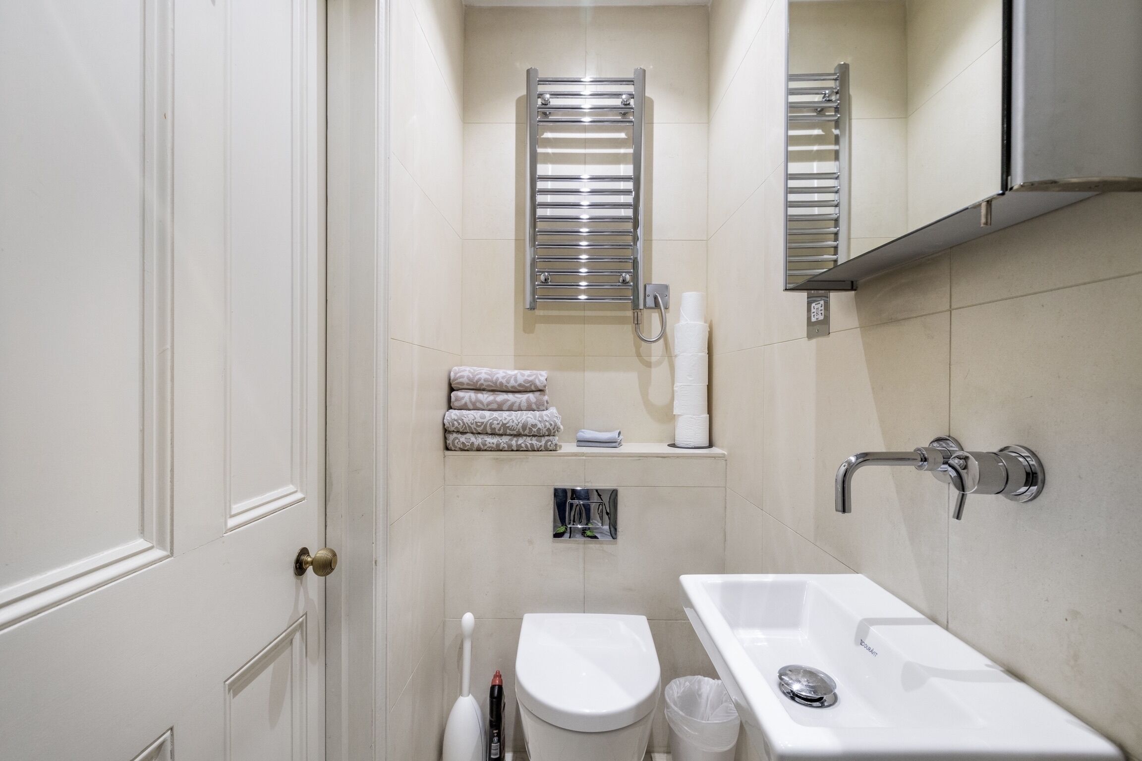 Une salle de bain comprenant des toilettes, un bidet, un lavabo, un porte-serviettes et un distributeur de serviettes.