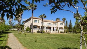 A large, two-story house with a paved driveway leading to a front porch.