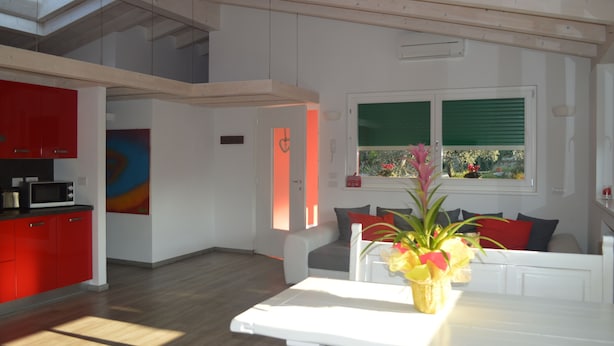 Ein modernes Interieur mit einer Küche, einem Essbereich und einem Wohnraum mit einem großen Fenster.
