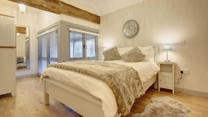 Una camera da letto con un letto, un comodino, una lampada e una finestra con persiane.