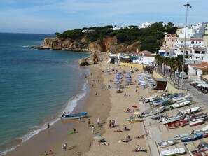 A beach with numerous boats and umbrellas, a rocky coastline, and buildings in the background. - Villa Estrelicia, Top Quality, Very Private 3 Bedroom Luxury Villa, Air Conditioning for 6-8 persons (Albufeira,)