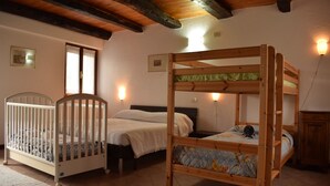 Quarto com cama de solteiro, berço e mesa de cabeceira.