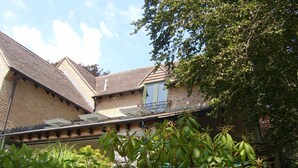 Un bâtiment doté d’un toit en pente, d’une petite porte et d’un balcon.