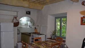 Une cuisine compacte équipée d’un réfrigérateur, d’une cuisinière et d’une table à manger pour quatre personnes.