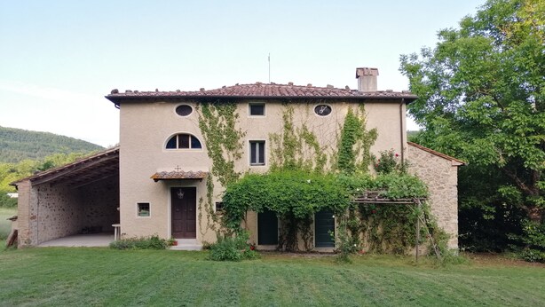 Un bâtiment rustique en pierre, doté d’un toit en tuiles, d’un porche abrité et d’une pelouse bien entretenue.