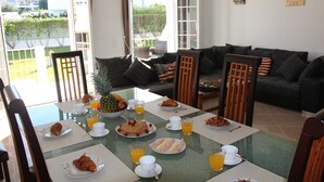 A dining area with a table set for breakfast, including plates of food, cups, and glasses of orange juice. - Luxury V5 | Pool & Jacuzzi | Beach 20 minutes walk | Groups & Families (Albufeira)