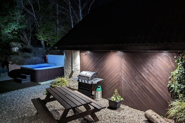 Lit hot tub and lighting in the landscaped garden. Picnic table, B.B.Q