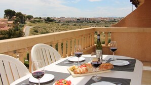 A table set for a meal with a view of a cityscape. - Modern apartment with great pool, next to harbour, boulevard and beach (el Campello)