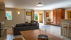 A spacious living area with a sofa, dining table, and a kitchen area with wooden cabinets. - House / Villa - DRAGUIGNAN (Draguignan)