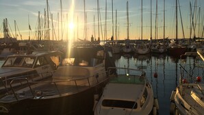 A marina with multiple boats docked, calm water, and the sun setting in the background. - Farmhouse in Klavze, Most na Soci, Primorska, Slovenia - Peaceful Location (Klavže)
