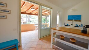 A kitchen with a wooden countertop, a sink, and a window overlooking a patio area. - Calaverde, very refined apartment a stone's throw from the sea (Pula)
