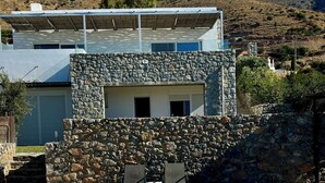Una casa moderna con facciata in pietra e piscina.