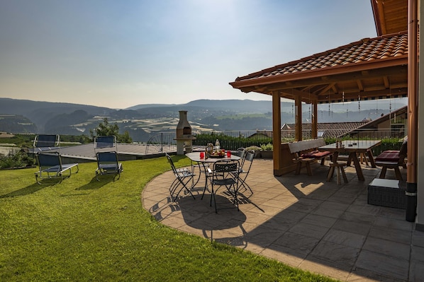 Un patio con mobili da esterno, un barbecue e vista sulla campagna.