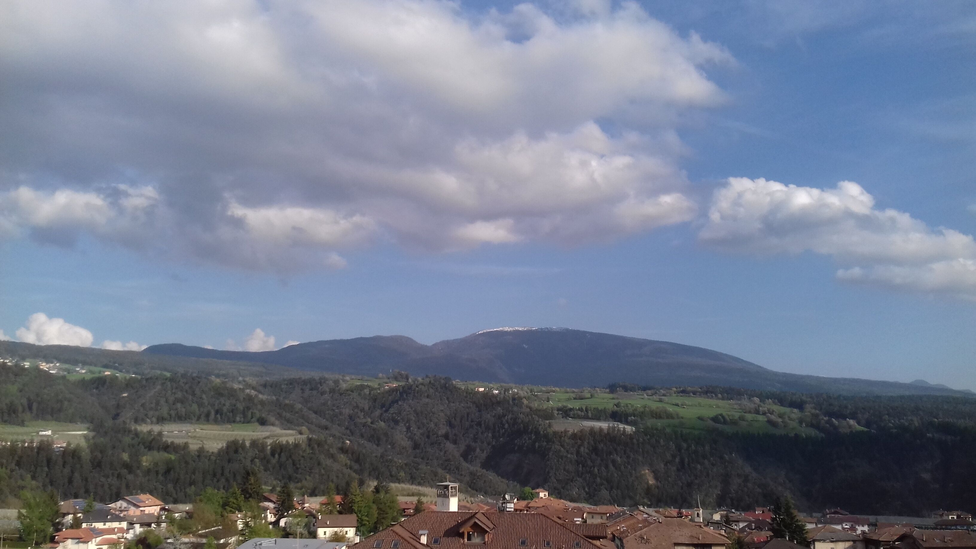 Un paysage montagneux avec un village au premier plan.