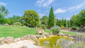 A garden with a pond, various plants, and a stone structure. - SES VELLETES 7 - Villa with private pool in Artà. (Artà)