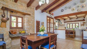 A rustic kitchen with stone walls, wooden beams, and a dining area with a wooden table and chairs. - SES VELLETES 7 - Villa with private pool in Artà. (Artà)