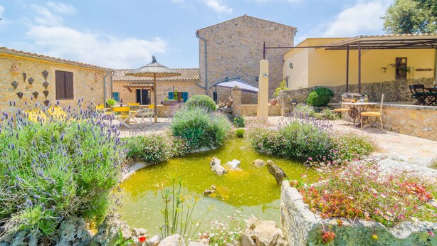 A courtyard with a pond, stone buildings, and outdoor seating. - SES VELLETES 7 - Villa with private pool in Artà. (Artà)