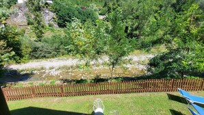 A backyard with a wooden fence, a small tree, and a grassy area. - Romantic Riverside Property, small private pool. WIFI . Walk to facilities (Borsigliana)
