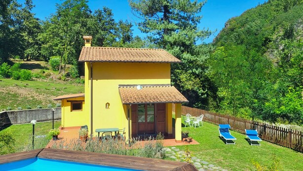 A yellow villa with a swimming pool, a patio with chairs, and a wooden fence. - Romantic Riverside Property, small private pool. WIFI . Walk to facilities (Borsigliana)