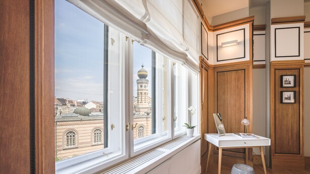 A room with large windows, a radiator, a small table with a lamp, and wooden paneling. - Wonderful suite overlooking the Great Synagogue. 110 m2 -WiFi - AC (Budapest)