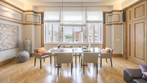 A spacious dining area with a large table, multiple chairs, and a city view through large windows. - Wonderful suite overlooking the Great Synagogue. 110 m2 -WiFi - AC (Budapest)