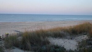 Une plage avec des dunes de sable et un ciel dégagé.