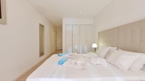 Ein Hotelzimmer mit einem großen Bett, einem Nachttisch mit Lampe und einem Kleiderschrank.