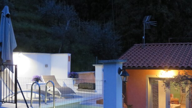 A residential area with a swimming pool, a covered patio, and a small building with a tiled roof. - Modern Cottage with Pool & Sun Terraces in Bagni Di Lucca. (Bagni di Lucca)