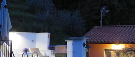 Zona residencial con piscina, terraza techada y un pequeño edificio de techo con tejas.