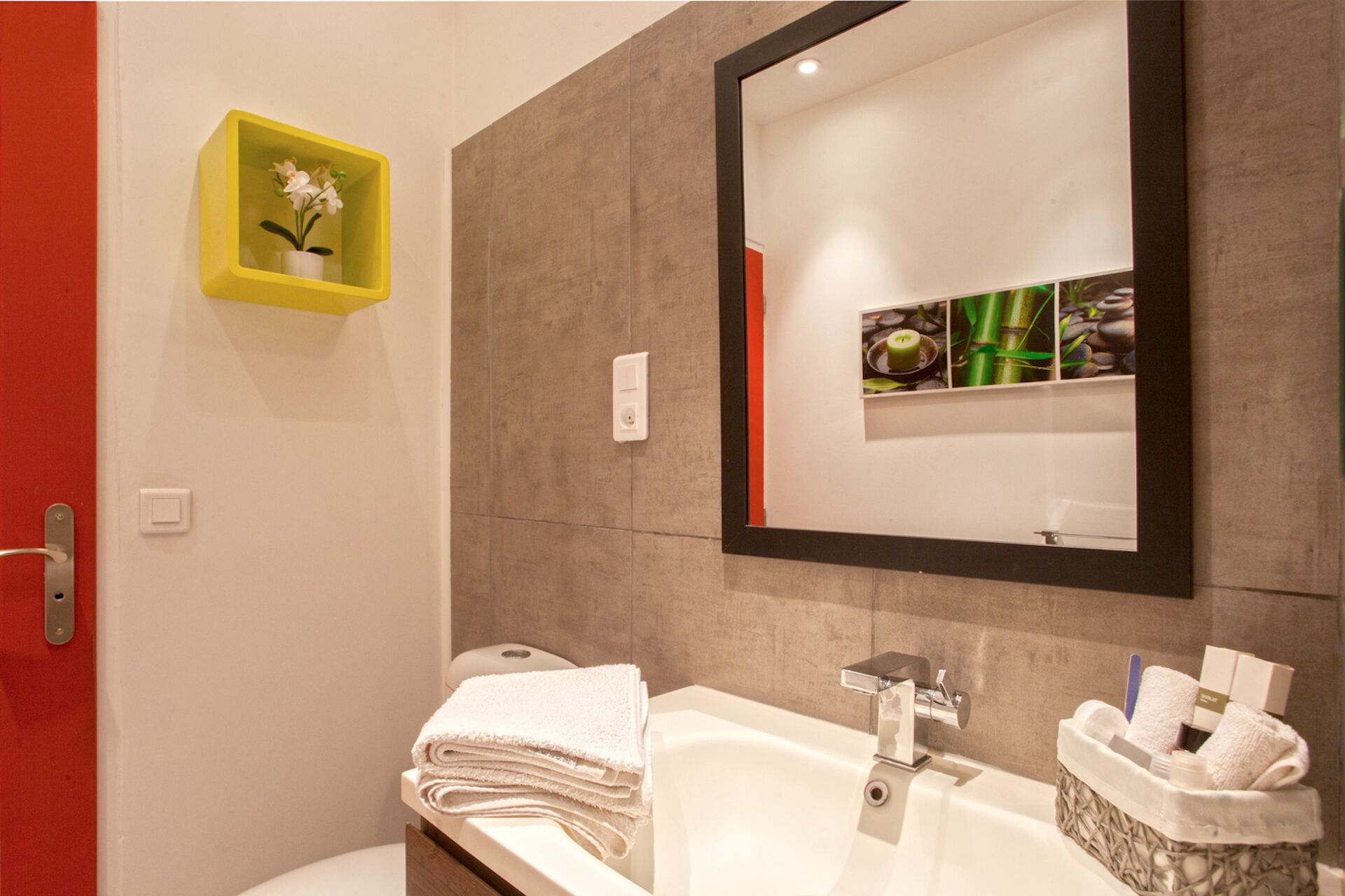 Un baño moderno con un espejo grande, un lavabo y un perchero para toallas.