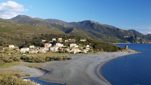 Un pueblo costero con edificios en una colina con vistas al mar.