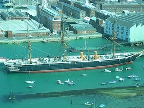 A large ship docked in a harbor with smaller boats around it. - 'The Haven' a luxury apartment close to the Meon Shore coast. (Fareham)